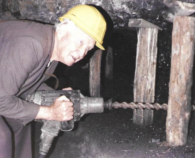 Tommy demonstrating the use of a borer in Wonthaggi mine. This piece of equipment saved a lot of time and labour when it was introduced.