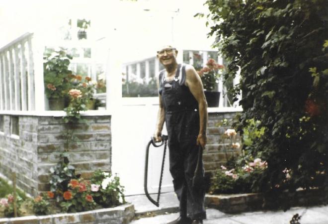 Tommy with his glasshouse, which he built himself from reclaimed materials in 1973