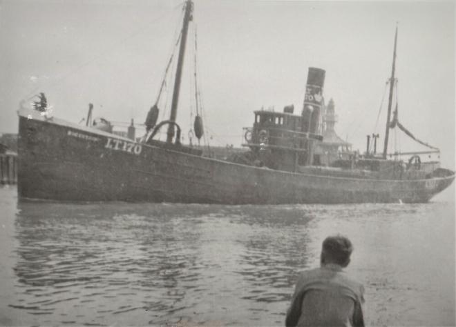 The steam trawler Bucentaur, LT 170, in harbour, with a man watching from the quayside